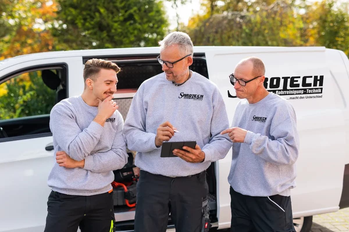 Sarotech-Team bespricht einen Auftrag am Firmenfahrzeug